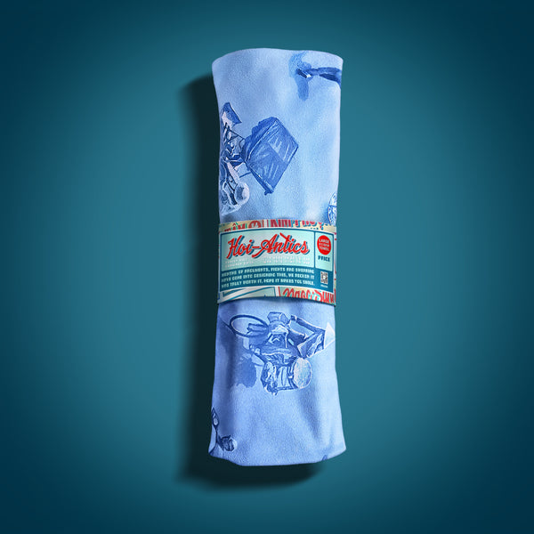 Front view of a rolled up large light blue beach towel with a pattern of people on bicycles and motorcycles, featuring Hoi-Antics brand wrapper.