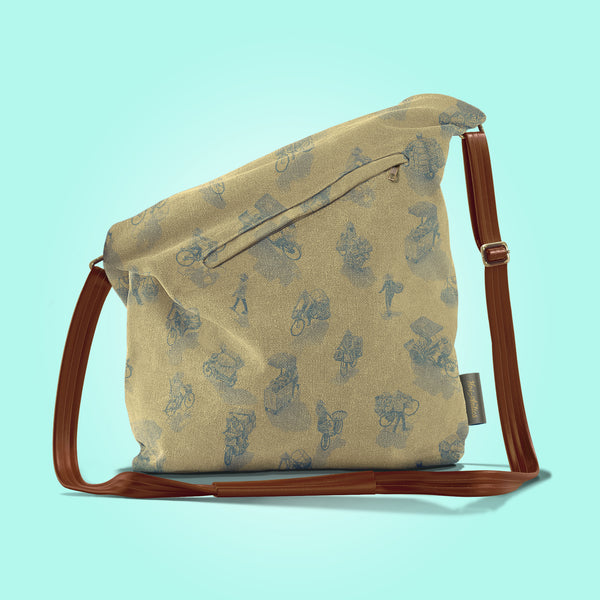 Back view of a closed antique yellow canvas and brown leather bag with a pattern of people on bicycles and motorcycles, featuring Hoi-Antics brand logo.