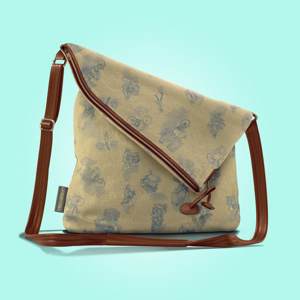 Front view of a closed antique yellow canvas and brown leather bag with a pattern of people on bicycles and motorcycles, featuring Hoi-Antics brand logo.