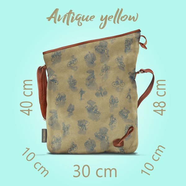 Front on view of a opened antique yellow canvas and brown leather bag, with a pattern of people on bicycles and motorcycles, featuring Hoi-Antics brand logo. With text dimensions and color title.