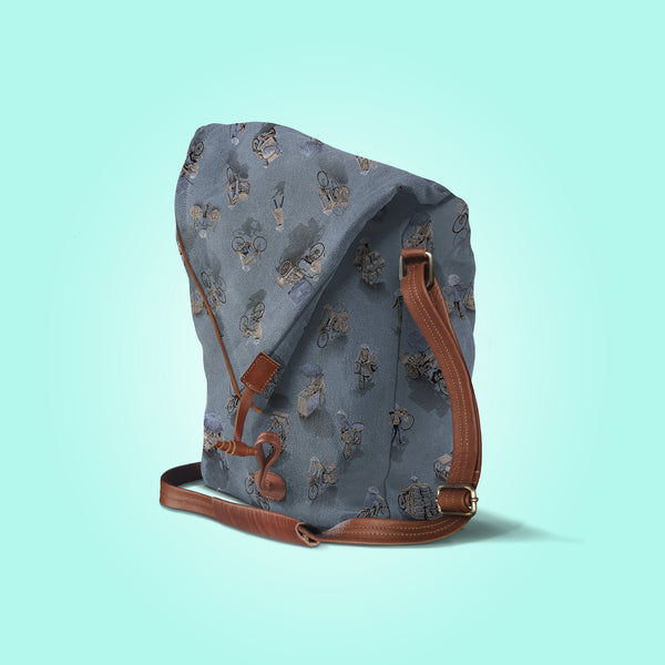 Three quarter view of a closed moonlit grey canvas and brown leather bag with a pattern of people on bicycles and motorcycles, featuring Hoi-Antics brand logo.