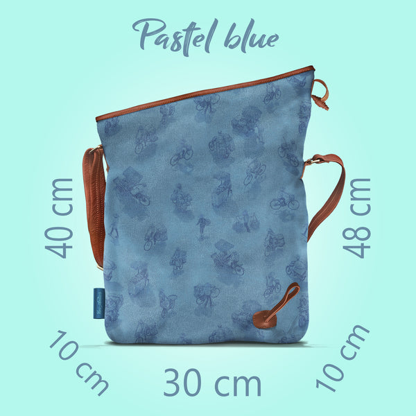Front on view of a opened pastel blue canvas and brown leather bag, with a pattern of people on bicycles and motorcycles, featuring Hoi-Antics brand logo. With text dimensions and color title.