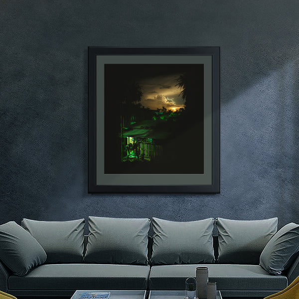 A Vietnamese night sky, printed on fine art paper, framed and hanging on a lounge wall, including a dramatic flash of lightning, a Vietnamese house with dramatic green and yellow lighting.