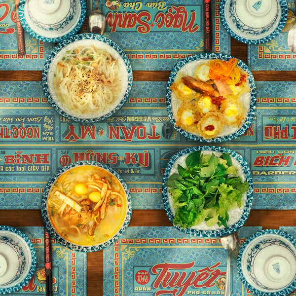 Distinct Vietnamese table mats and runner, printed on canvas fabric, featuring Vietnamese shop sign artwork, borders and patterns, with Vietnamese food