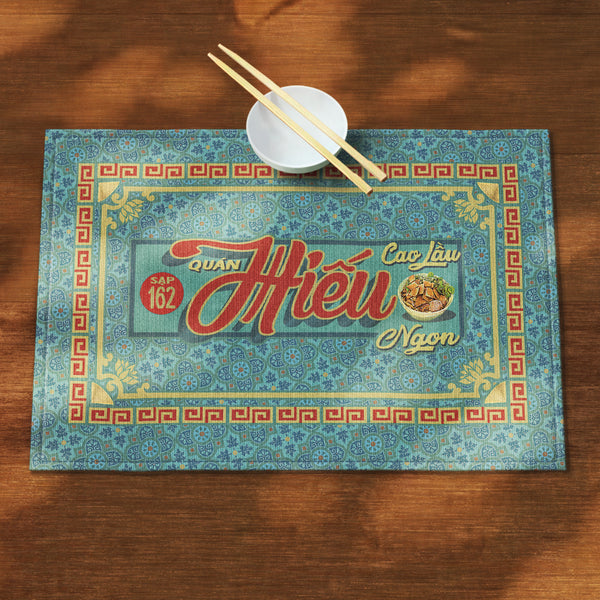 A distinct Vietnamese table mat, printed on canvas fabric, featuring a Vietnamese shop sign artwork, border and pattern.