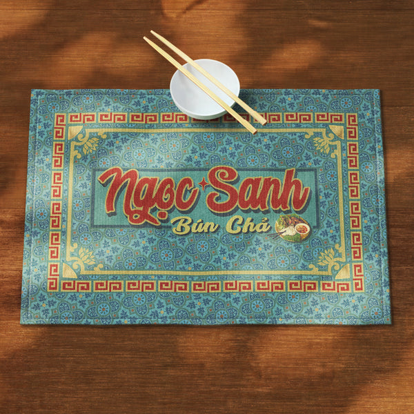A distinct Vietnamese table mat, printed on canvas fabric, featuring a Vietnamese shop sign artwork, border and pattern.