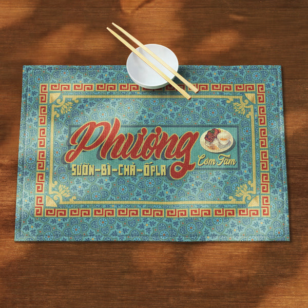 A distinct Vietnamese table mat, printed on canvas fabric, featuring a Vietnamese shop sign artwork, border and pattern.