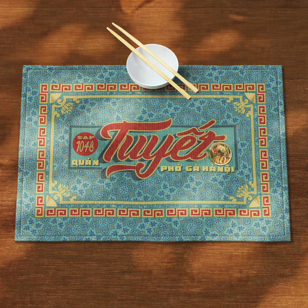 A distinct Vietnamese table mat, printed on canvas fabric, featuring a Vietnamese shop sign artwork, border and pattern.