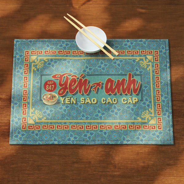 A distinct Vietnamese table mat, printed on canvas fabric, featuring a Vietnamese shop sign artwork, border and pattern.