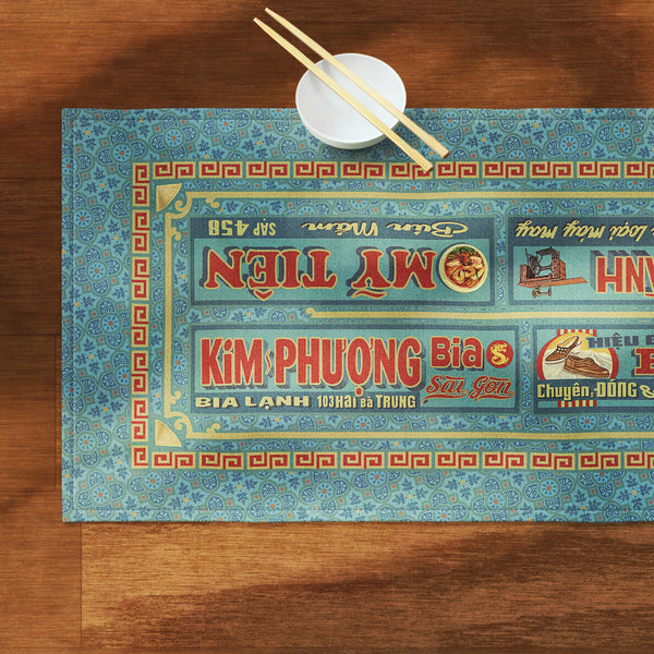 A distinct Vietnamese table runner, printed on canvas fabric, featuring Vietnamese shop sign artwork, borders and patterns.